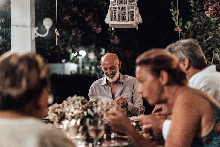 Analogue Photograph With Grain Of People Dinning And Flowers On Table