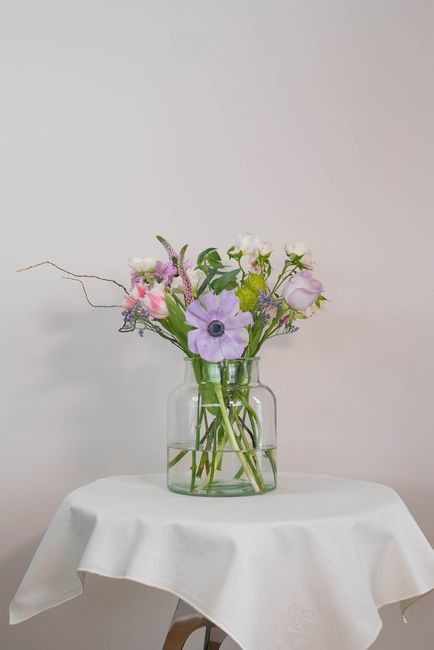 Beautiful mixed flowers in a glass vase on a draped table, enhancing any space.