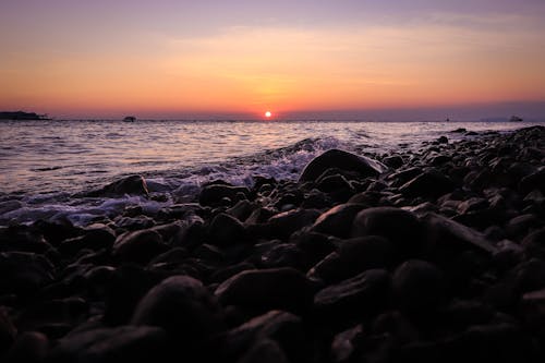 Black Rocks on Sea During Sunset
