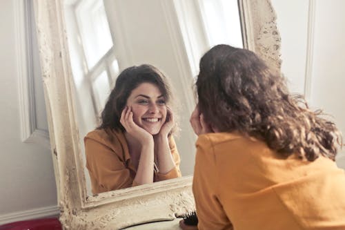 Foto Di Donna Che Guarda Allo Specchio