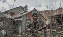 Man in Green and Brown Camouflage Jacket Holding Brown Rifle