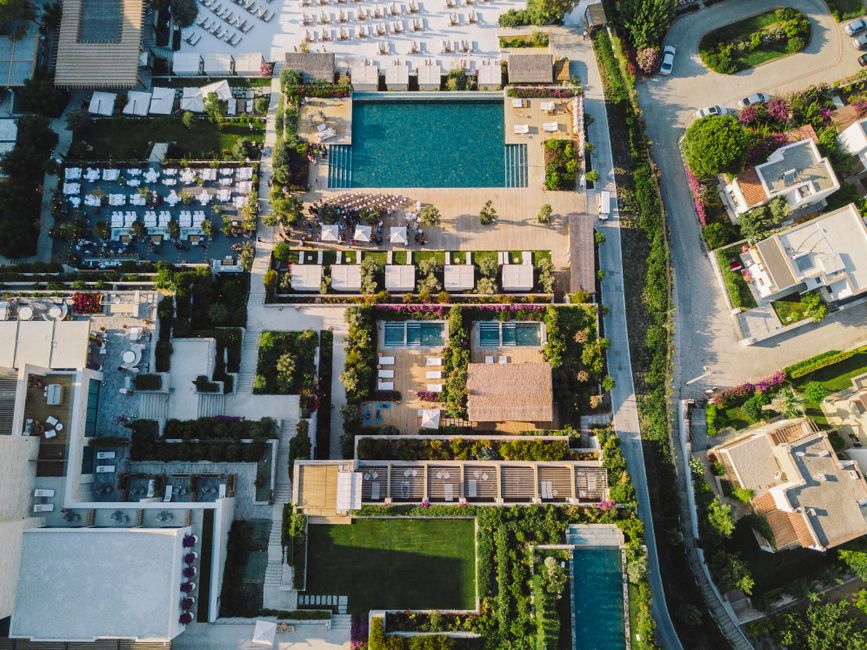 Stunning birds-eye view of a luxurious resort featuring lush gardens and sparkling pools.
