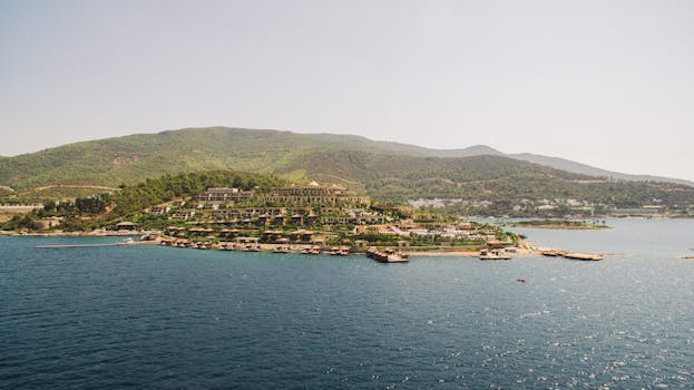 A breathtaking aerial view of a green island with lush hills and azure seas.