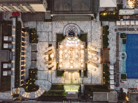 Stunning aerial shot of a luxurious resort featuring a grand courtyard and an illuminated swimming pool.