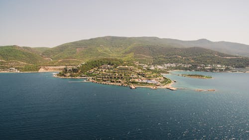 Aerial View of Buildings Surrounded by Trees on Mountain Ranges