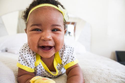 無料 白と黄色のシャツを着ている赤ちゃん 写真素材