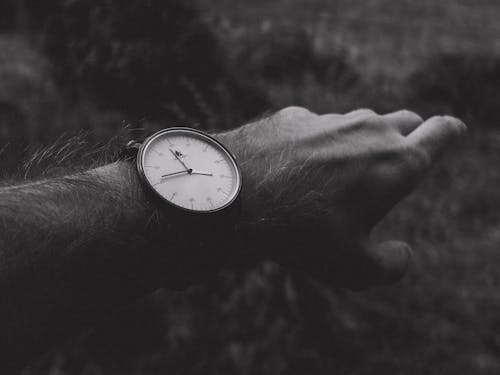 Monochrome Photograph of a Person Wearing an Analog Watch
