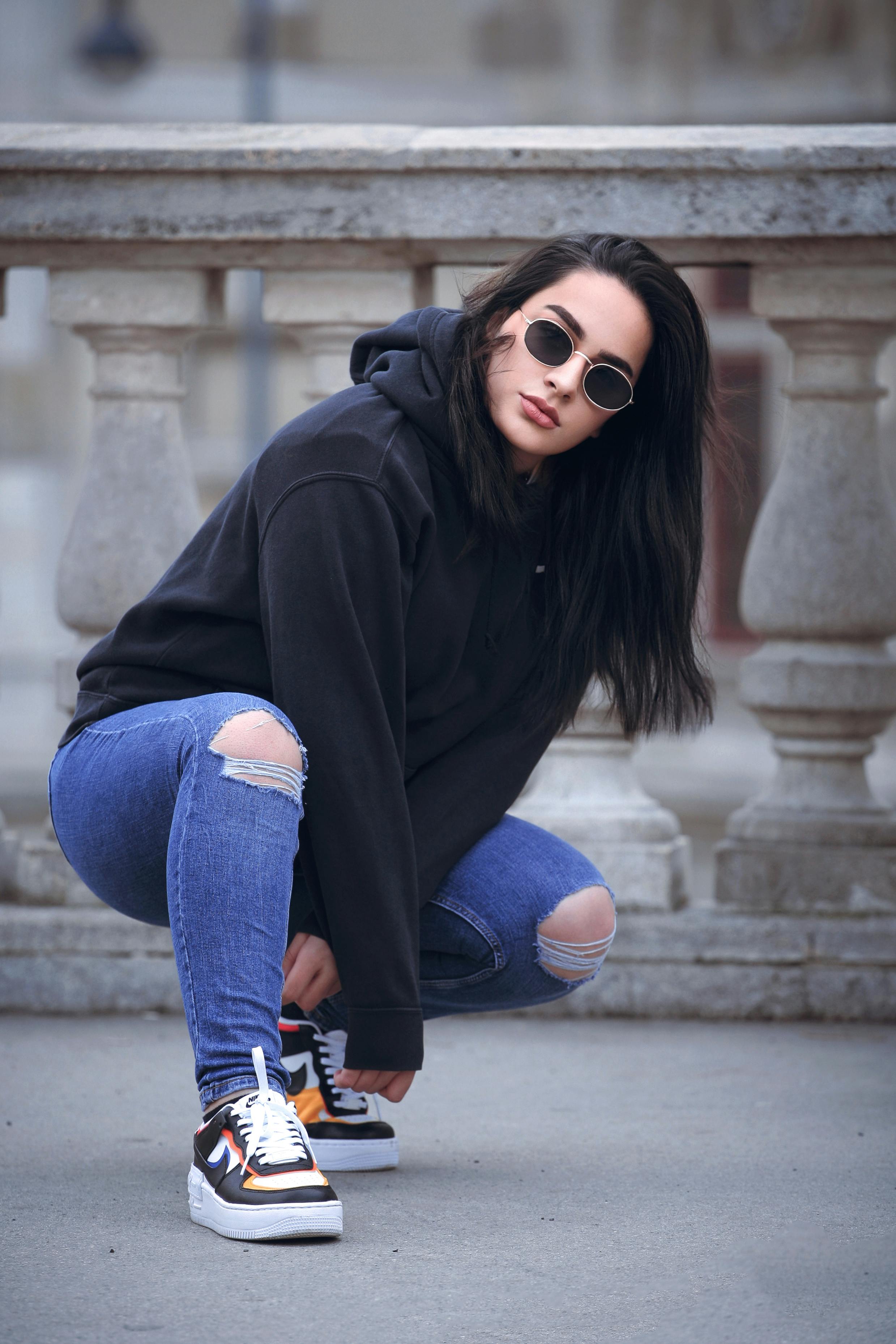 A Fashionable Woman in Black Hoodie Jacket and Ragged Denim Pants ...