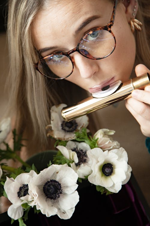 Free Photo of a Woman Playing the Flute Near Poppy Flowers Stock Photo