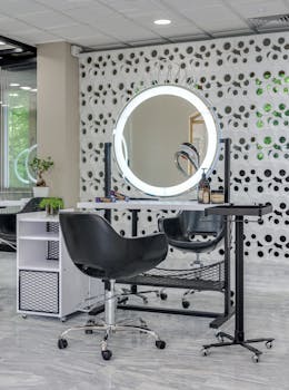 Chic salon setup featuring sleek chairs and illuminated vanity mirror.