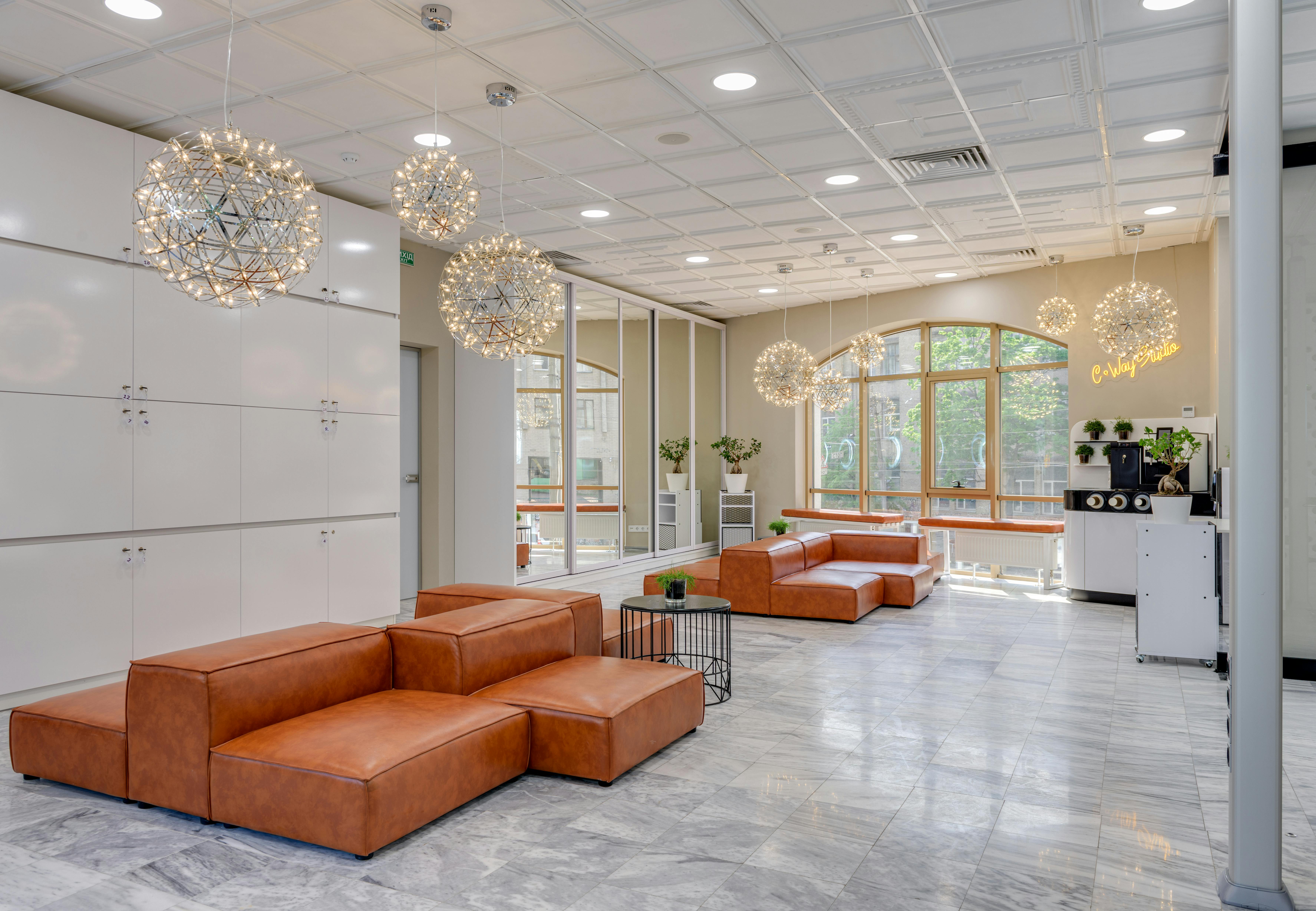 Free Spacious office lounge with leather couches and hanging lights. Stock Photo