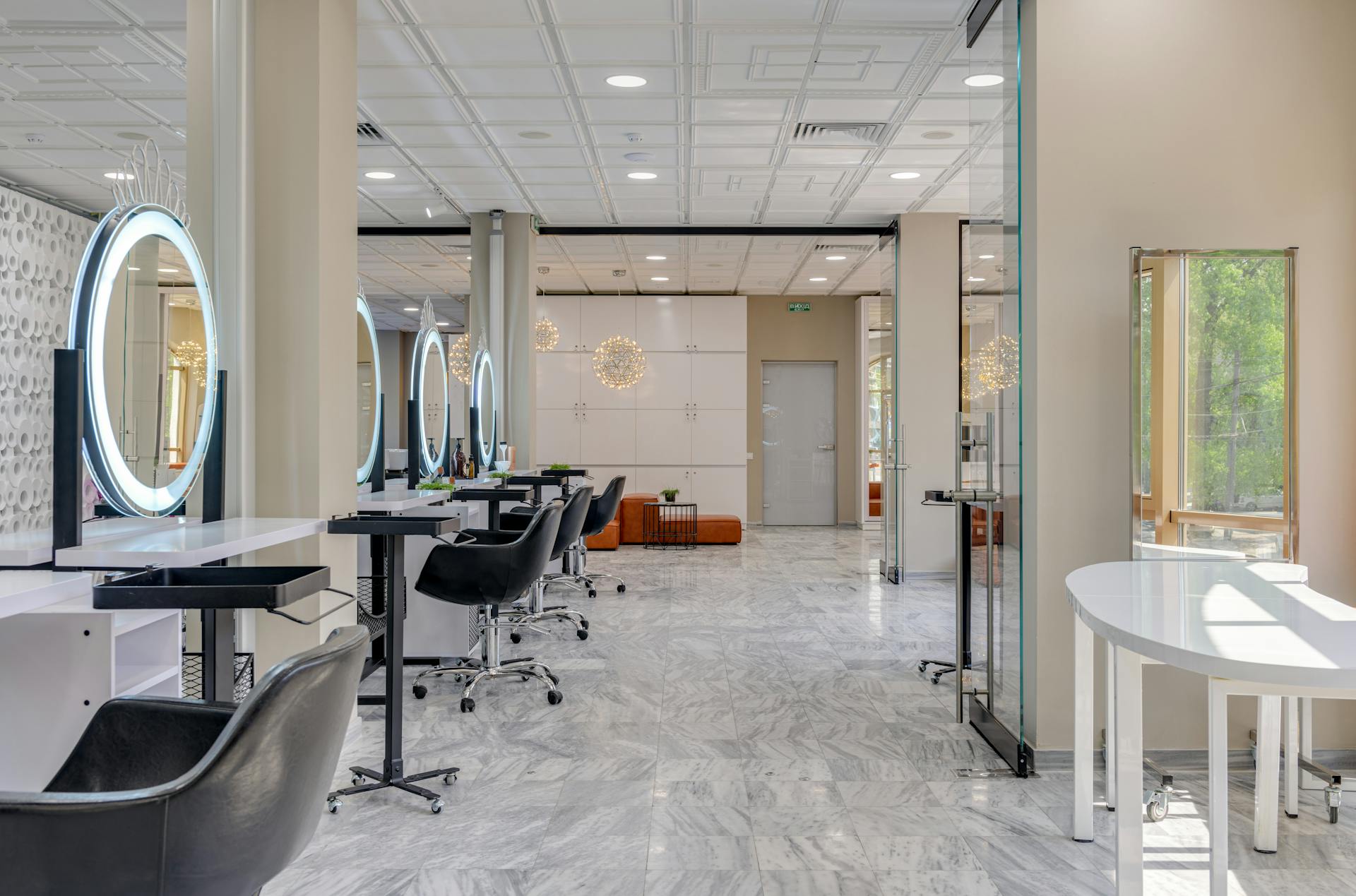 Explore a spacious and contemporary beauty salon interior featuring sleek design, mirrors, and luxurious seating.