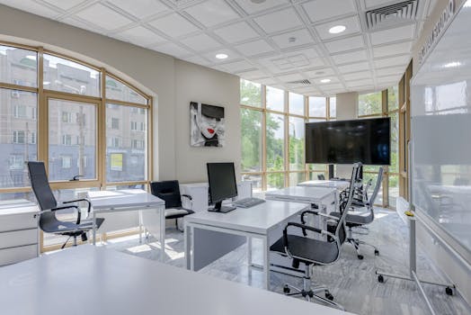 Contemporary minimalist office with glass windows and ergonomic chairs.