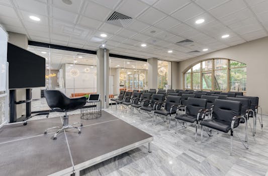 Spacious office setup with black chairs and a presentation stage.