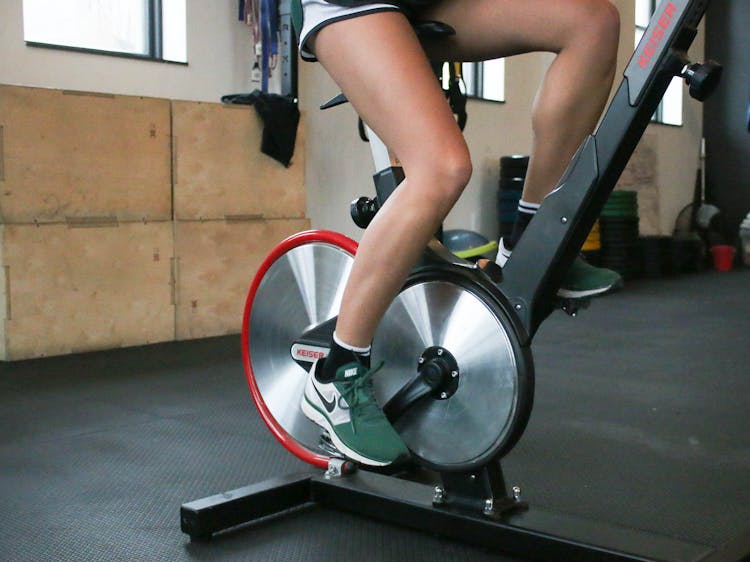 Person Exercising On Cycling Machine In Gym