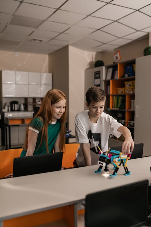 Two Children Playing with a Robotics Device