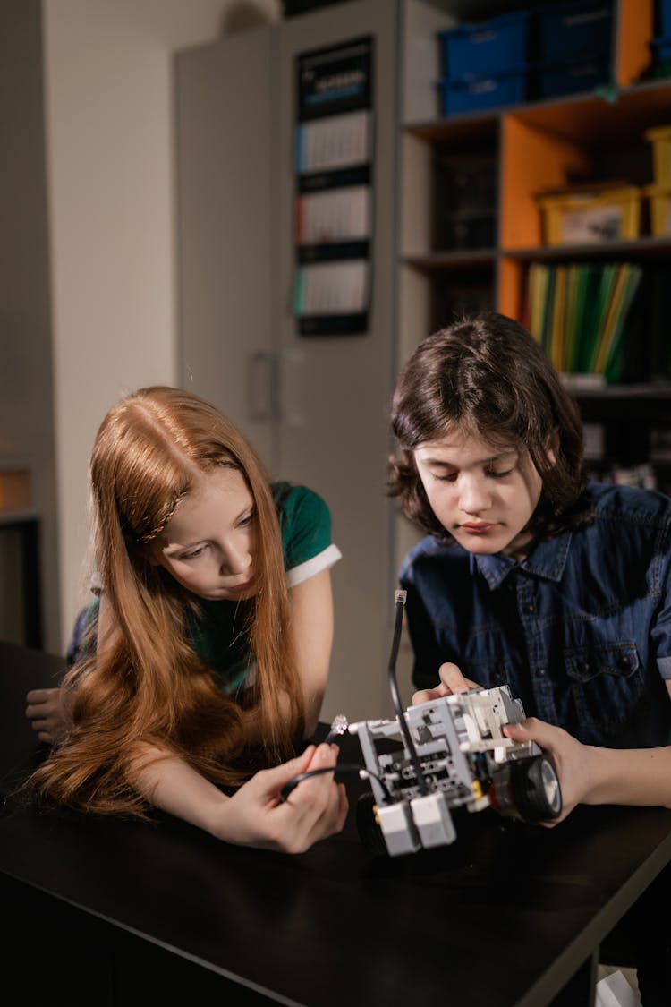 A Boy And A Girl Holding A Toy Car