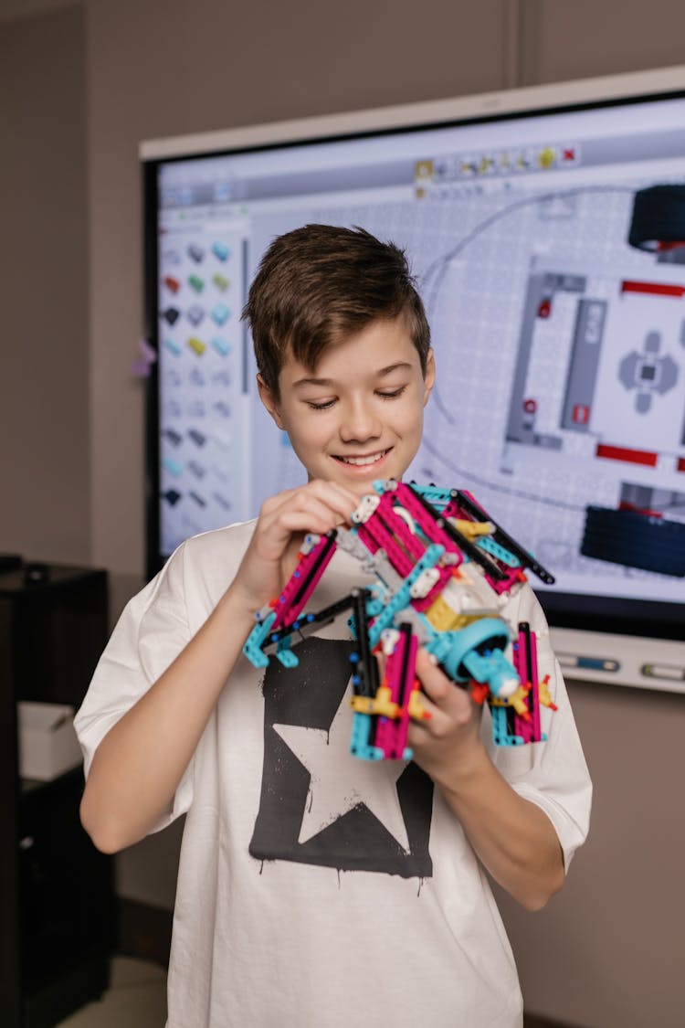 Boy In White Shirt Holding A Plastic Robot