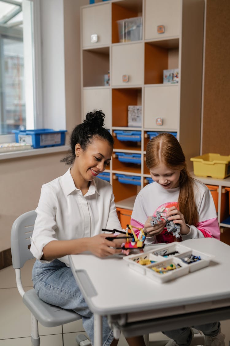 A Teacher And Her Student Playing Legos