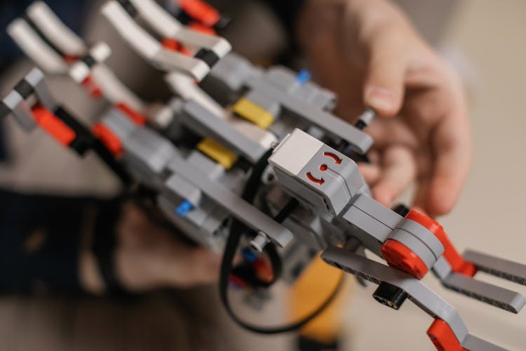 Anonymous Man Assembling Toy Robot In Daytime