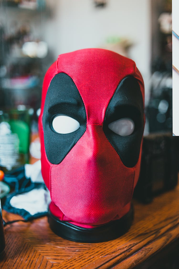 Deadpool Toy Head On Wooden Surface