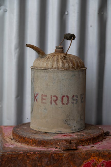 Close-up of an old, rusty kerosene can on a metal surface with corrugated backdrop.