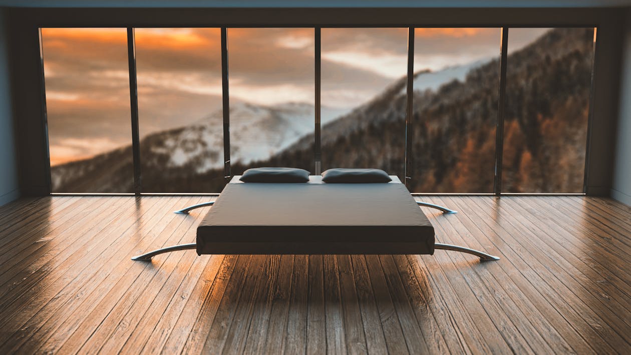 Free Black Mattress in Front of a Large Window Behind a Mountain Stock Photo