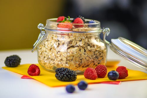 Selective Focus Photo of a Glass Jar with Oats and Fruits