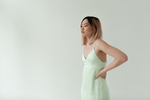 A Woman Wearing a Green Dress Posing with Her hand on Waist