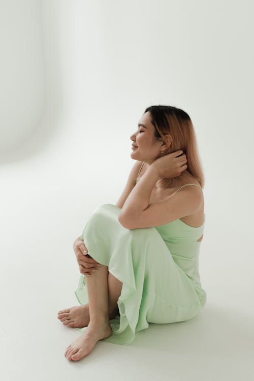 A Woman in Green Dress Sitting on the Floor 