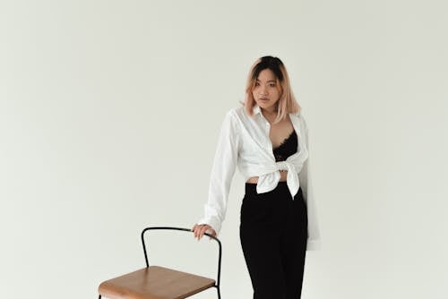 Woman in White Top Holding a Chair