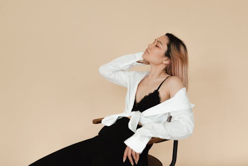 Woman in White Top Sitting on a Chair