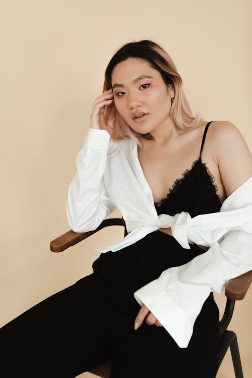 Woman Posing While Sitting on Brown Wooden Chair