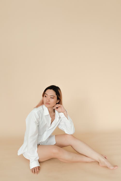 Woman in White Long Sleeve Shirt Sitting on the Floor