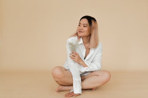 Free Woman in White Long Sleeves Sitting on the Floor Stock Photo