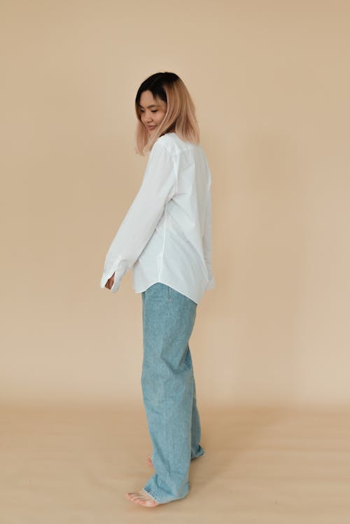 A Pretty Woman in White Long Sleeves and Denim Pants