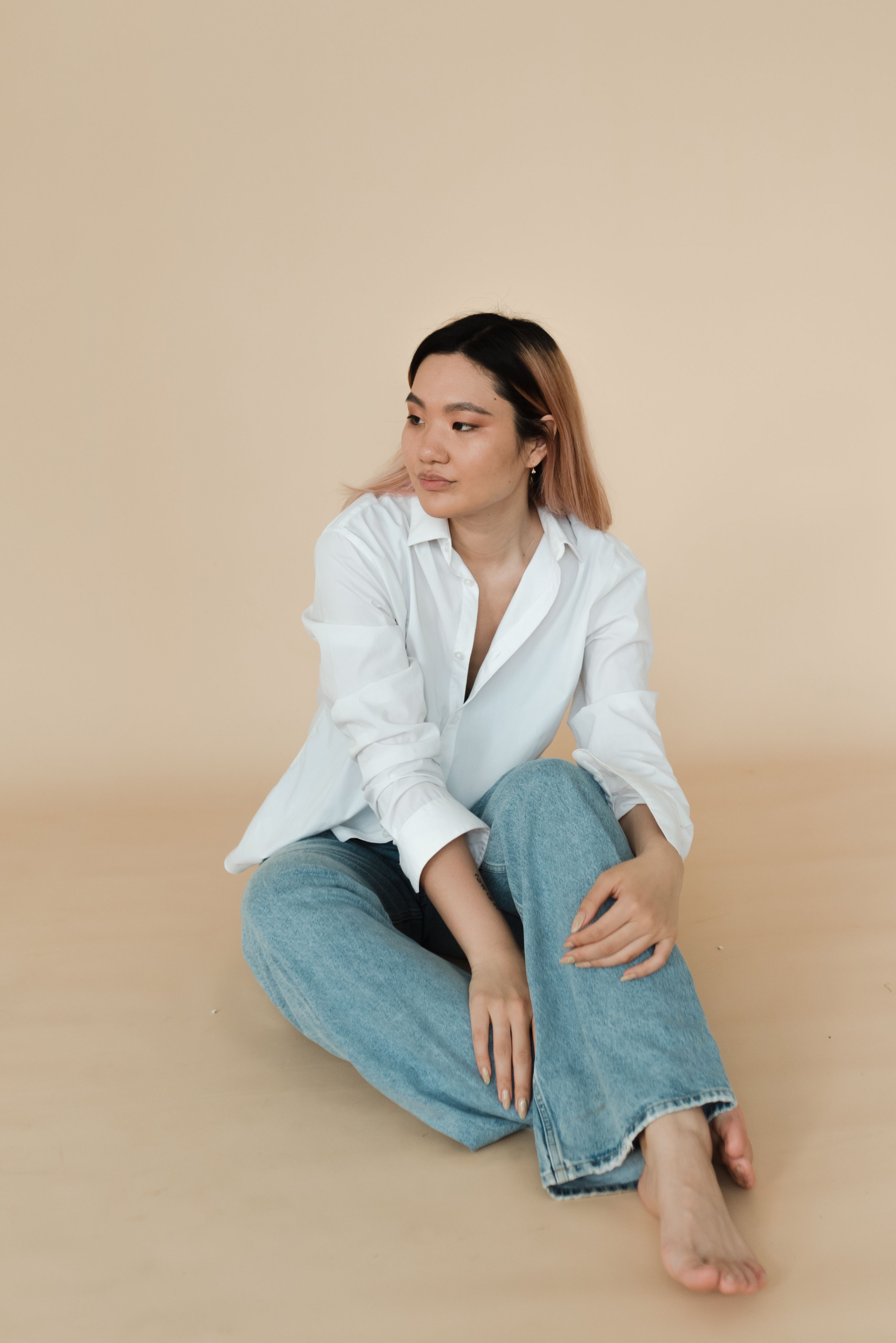 Woman in White Top and Denim Jeans Sitting on a Chair · Free Stock Photo