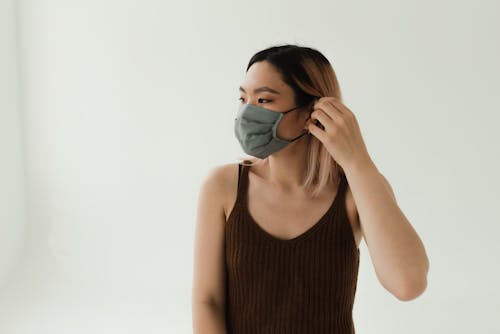 A Woman in Brown Tank Top Wearing a Face Mask