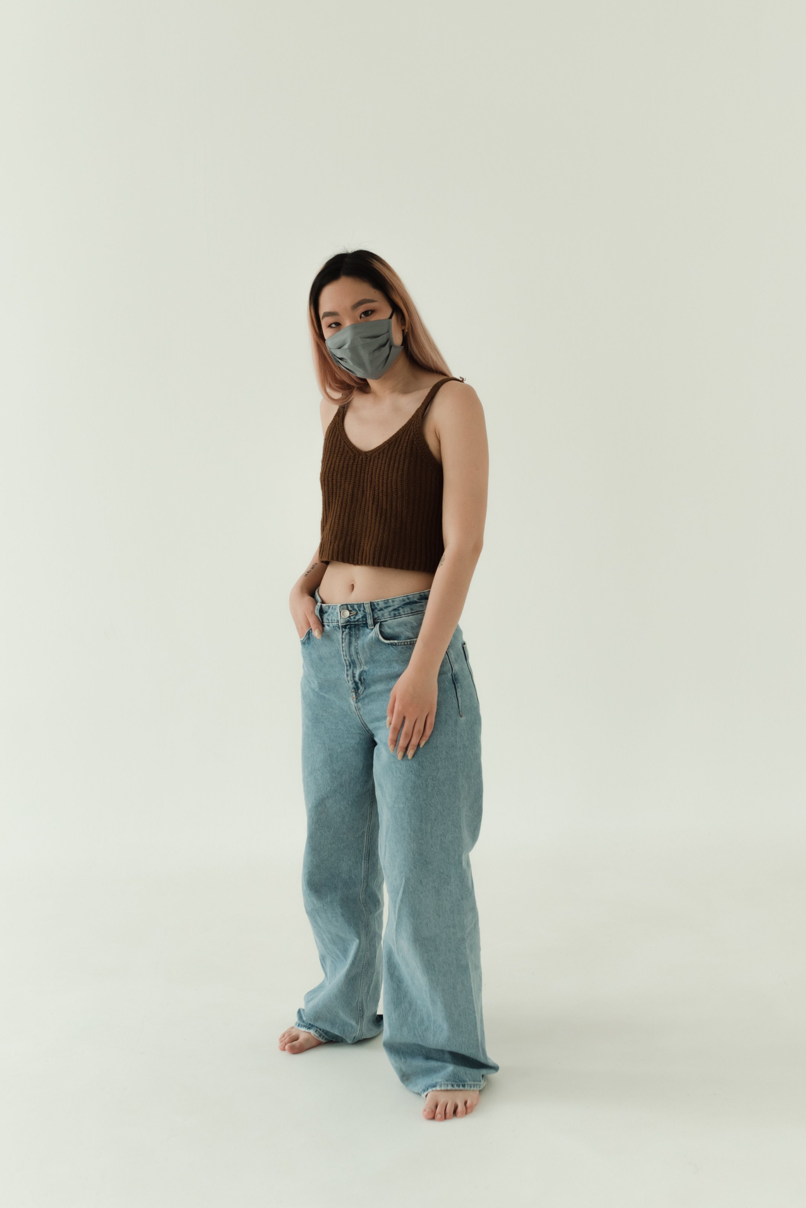 A Woman in Brown Tank Top and Blue Denim Jeans with Face Mask · Free ...