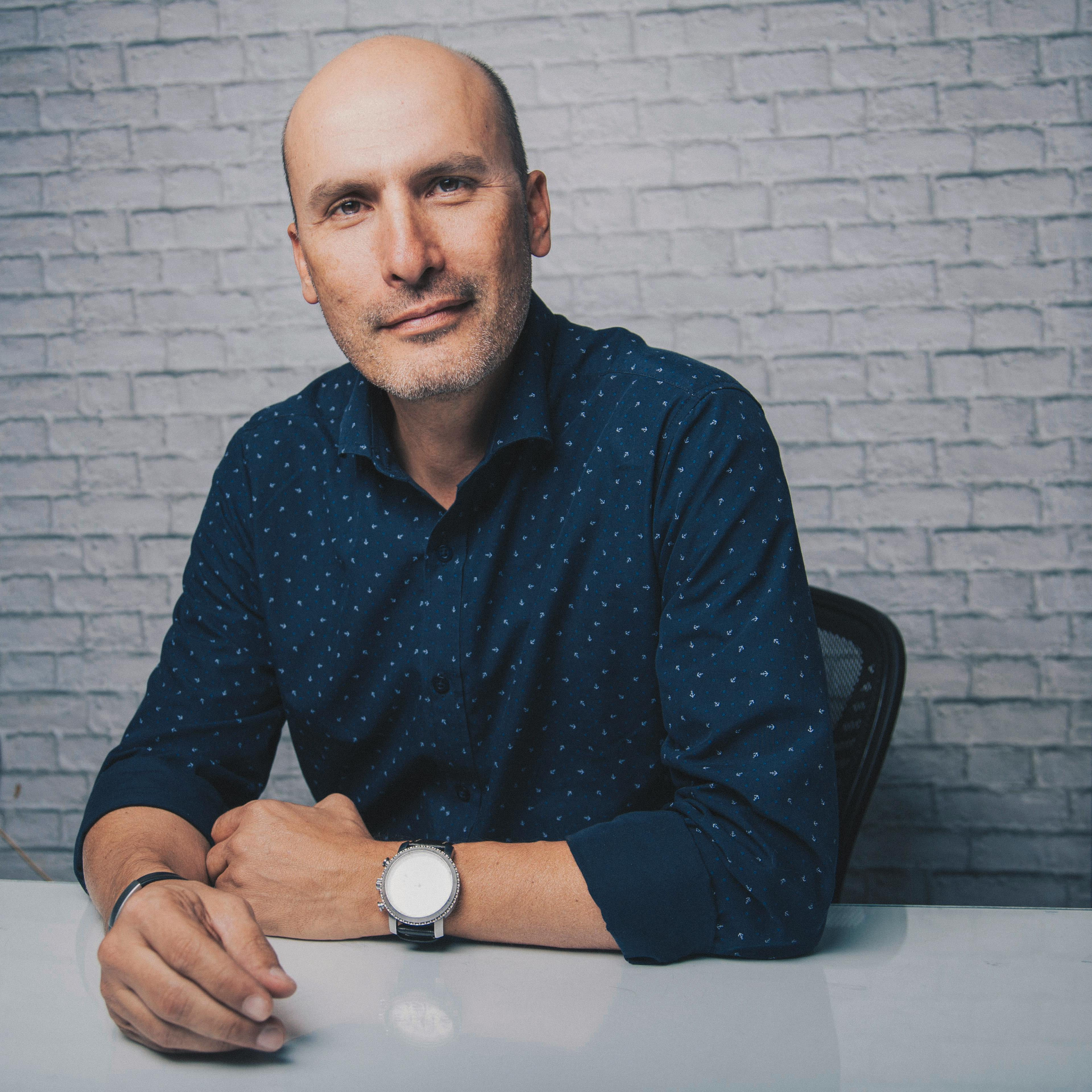 confident man in stylish outfit sitting at table