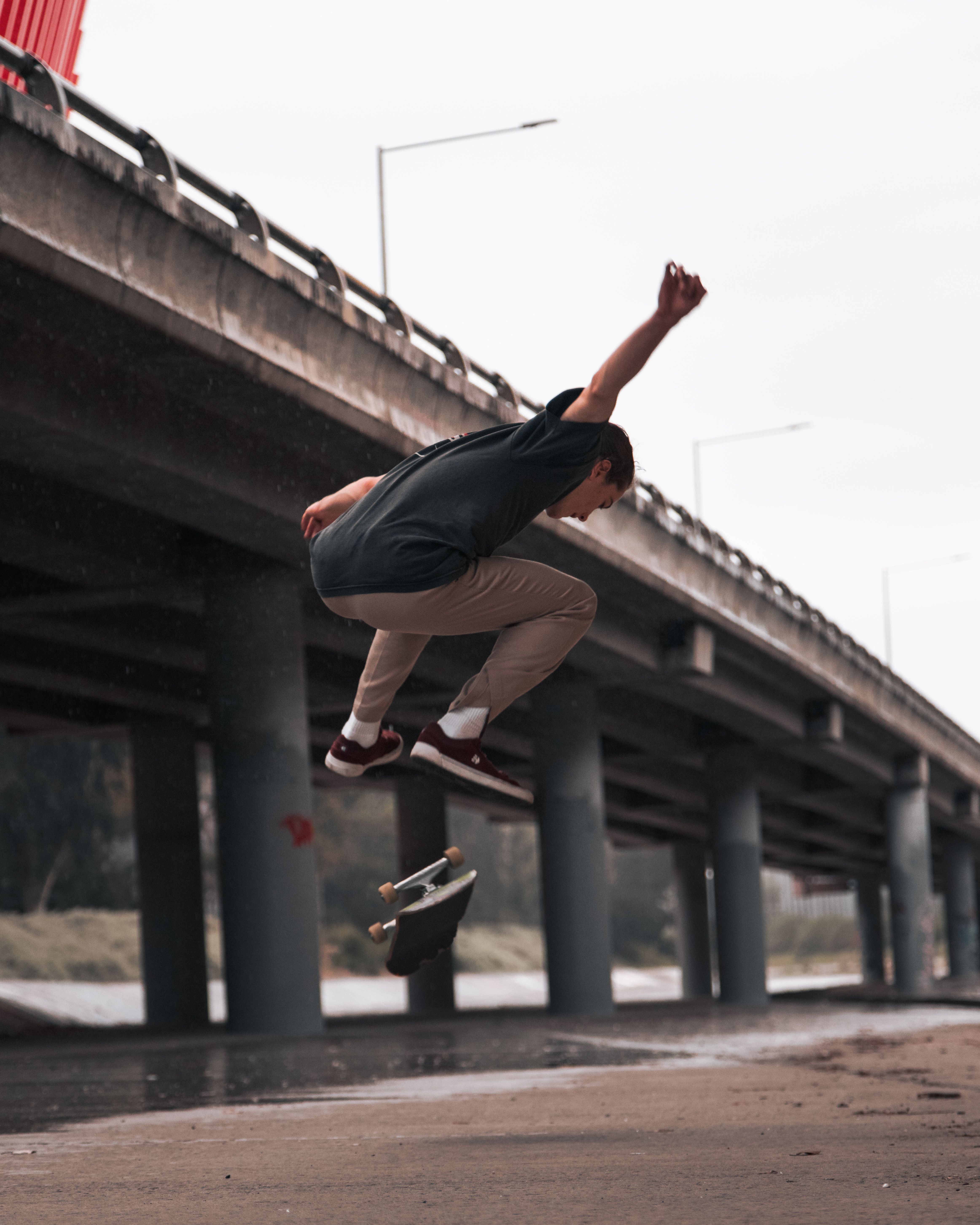 Skateboarder performs a trick under a bridge in Melbourne, capturing the thrill of urban skateboarding.. pexels, skateboarder