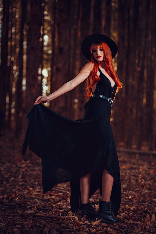 Free Woman in Black Dress Standing on Fallen leaves Stock Photo