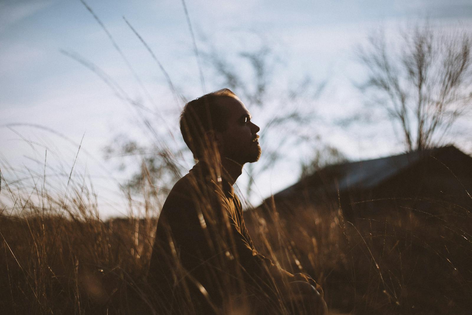 Man meditating in a field of wheat.