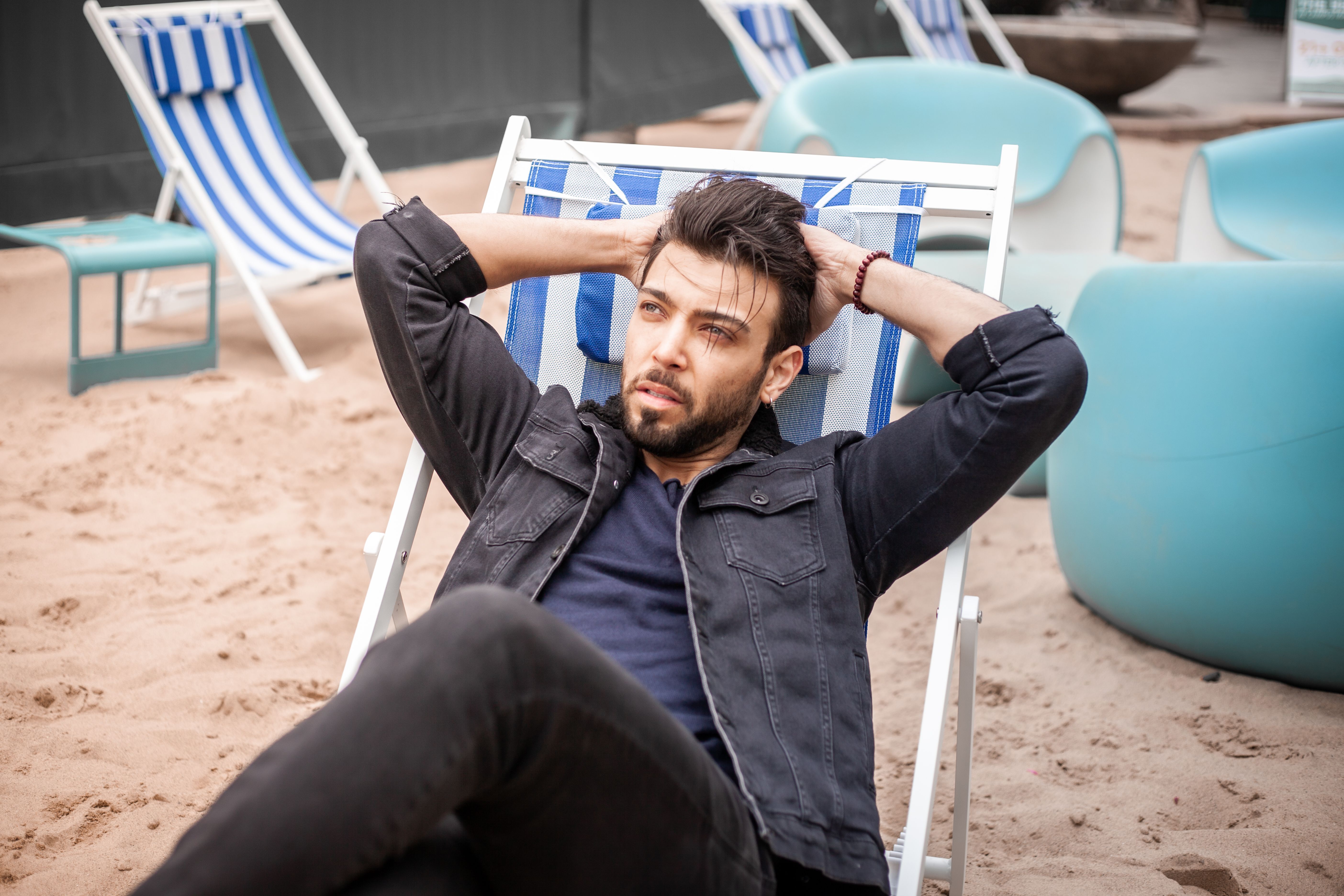 Mann entspannt allein auf der Lounge unter der Pergola