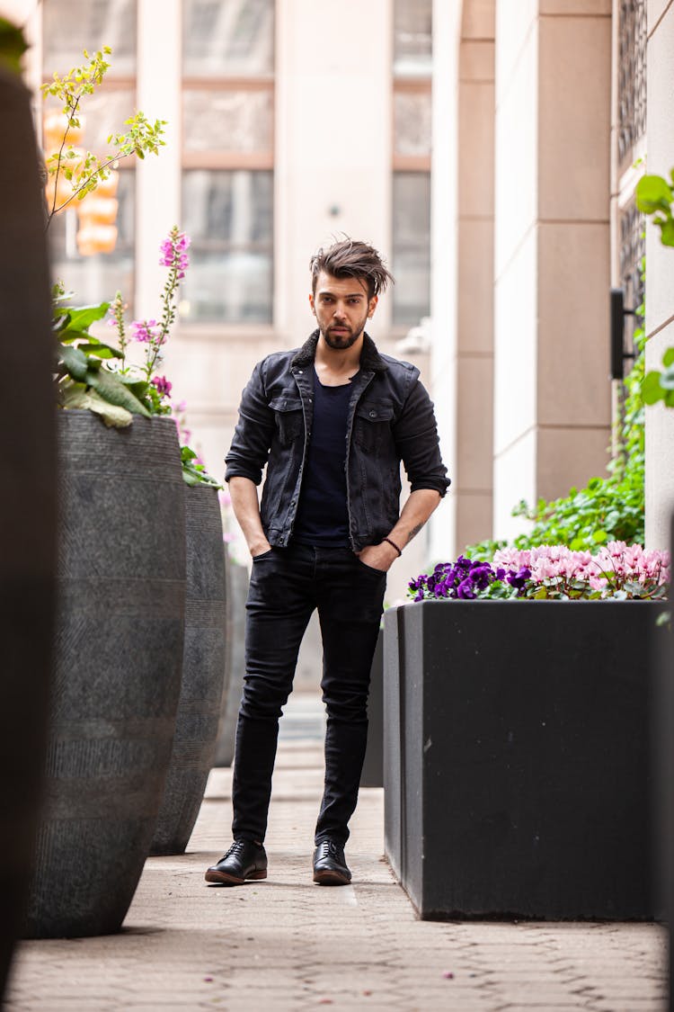 Man In Black Casual Wear Standing Near Potted Flowers