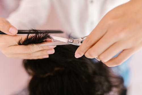 Free Person Cutting Hair Using a Silver Scissors Stock Photo