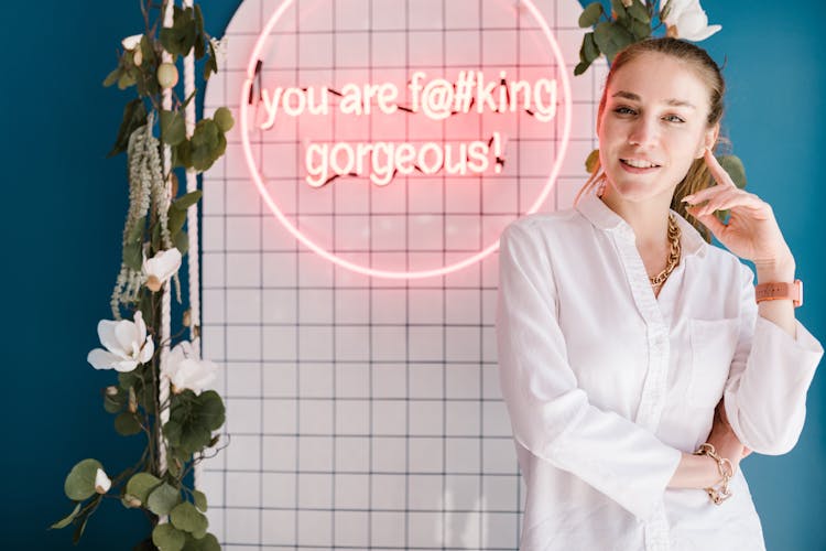 Woman Posing Near Pink Neon Sign 