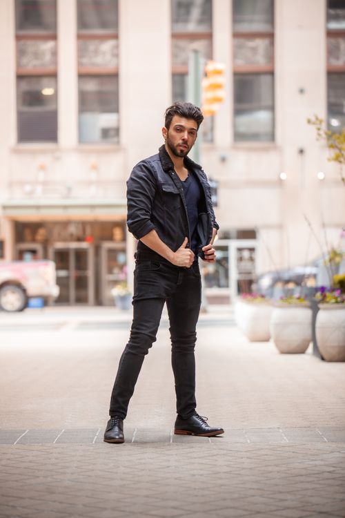 Free Confident man posing stylishly in urban street setting, embodying modern fashion vibes. Stock Photo
