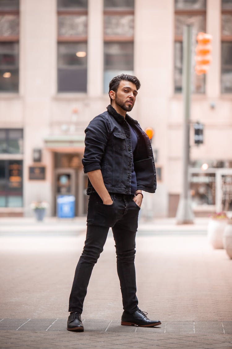 Man In Black Jacket And Black Jeans Standing On Pavement