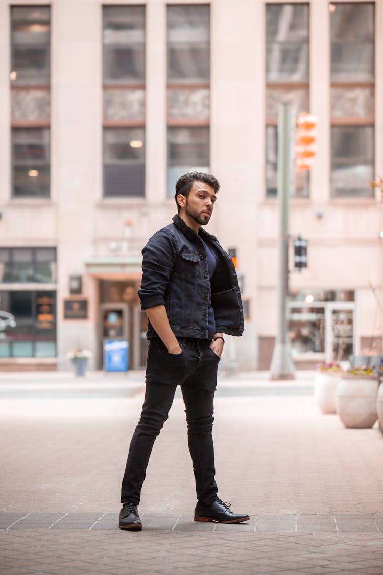 Man In Black Leather Jacket And Black Jeans Standing On Pavement